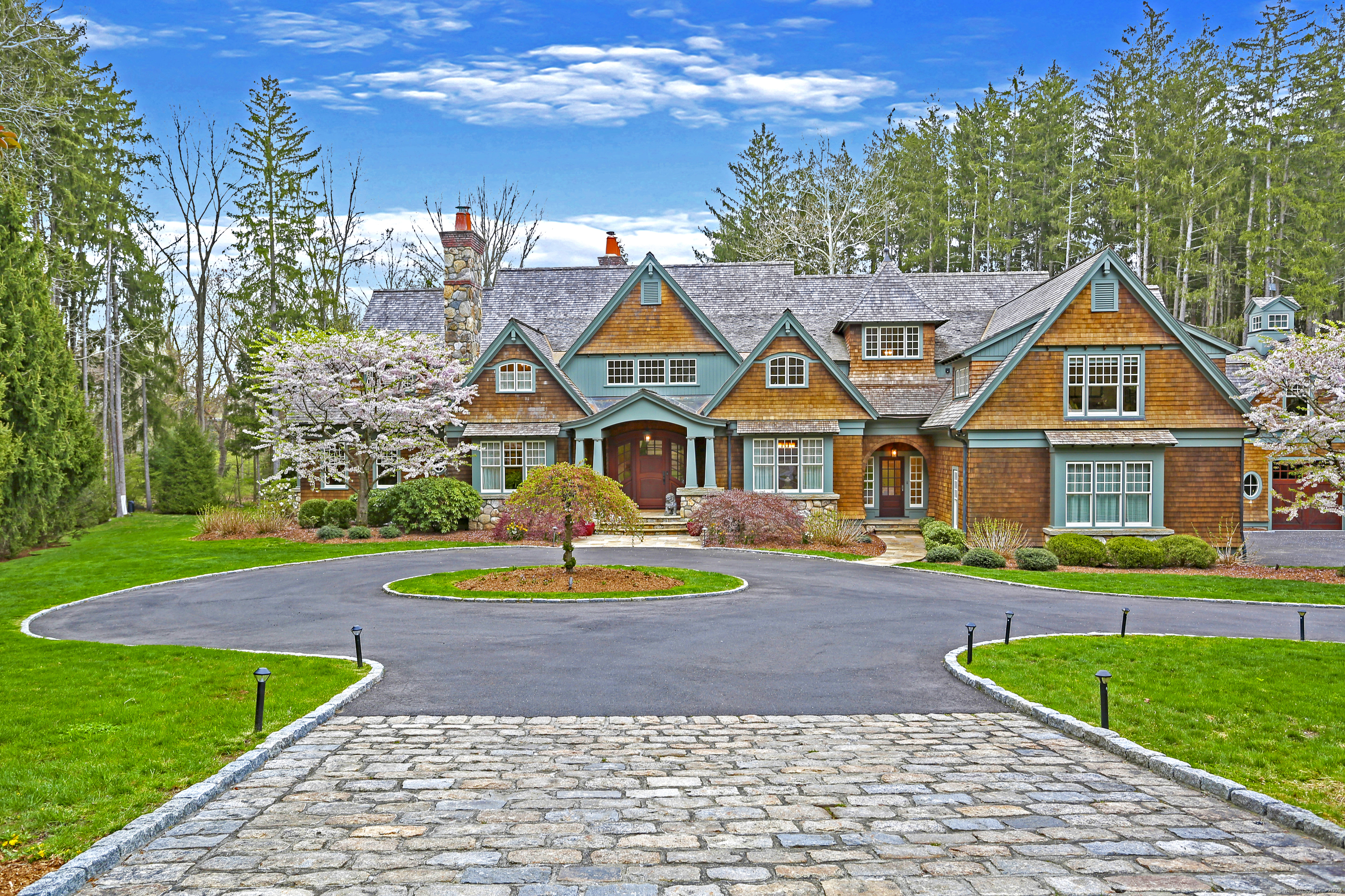 a view of a big house with a big yard and potted plants