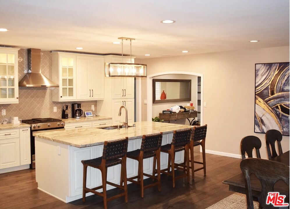 a kitchen with a dining table chairs and white cabinets