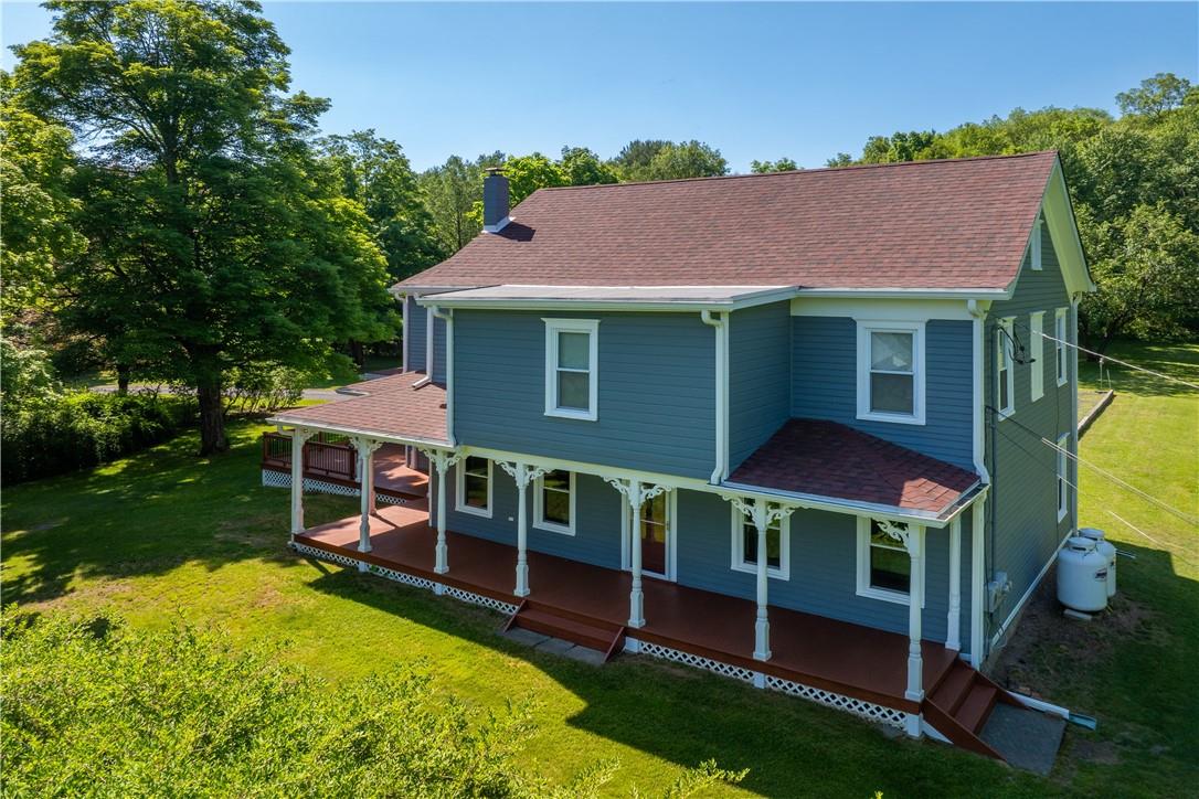 Back of property with a yard and covered porch