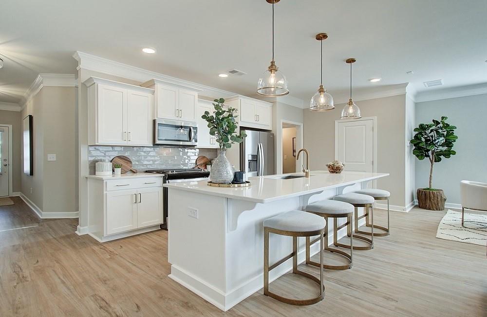 a kitchen with stainless steel appliances kitchen island a table and chairs in it