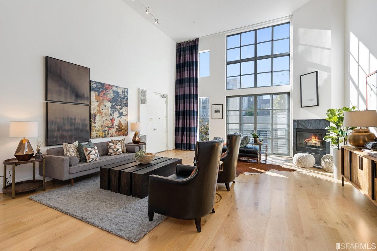 a living room with furniture potted plant floor to ceiling windows and a rug