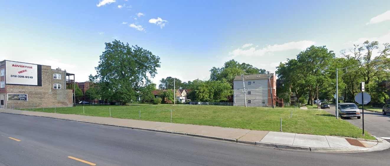 a view of a building with a yard and a street