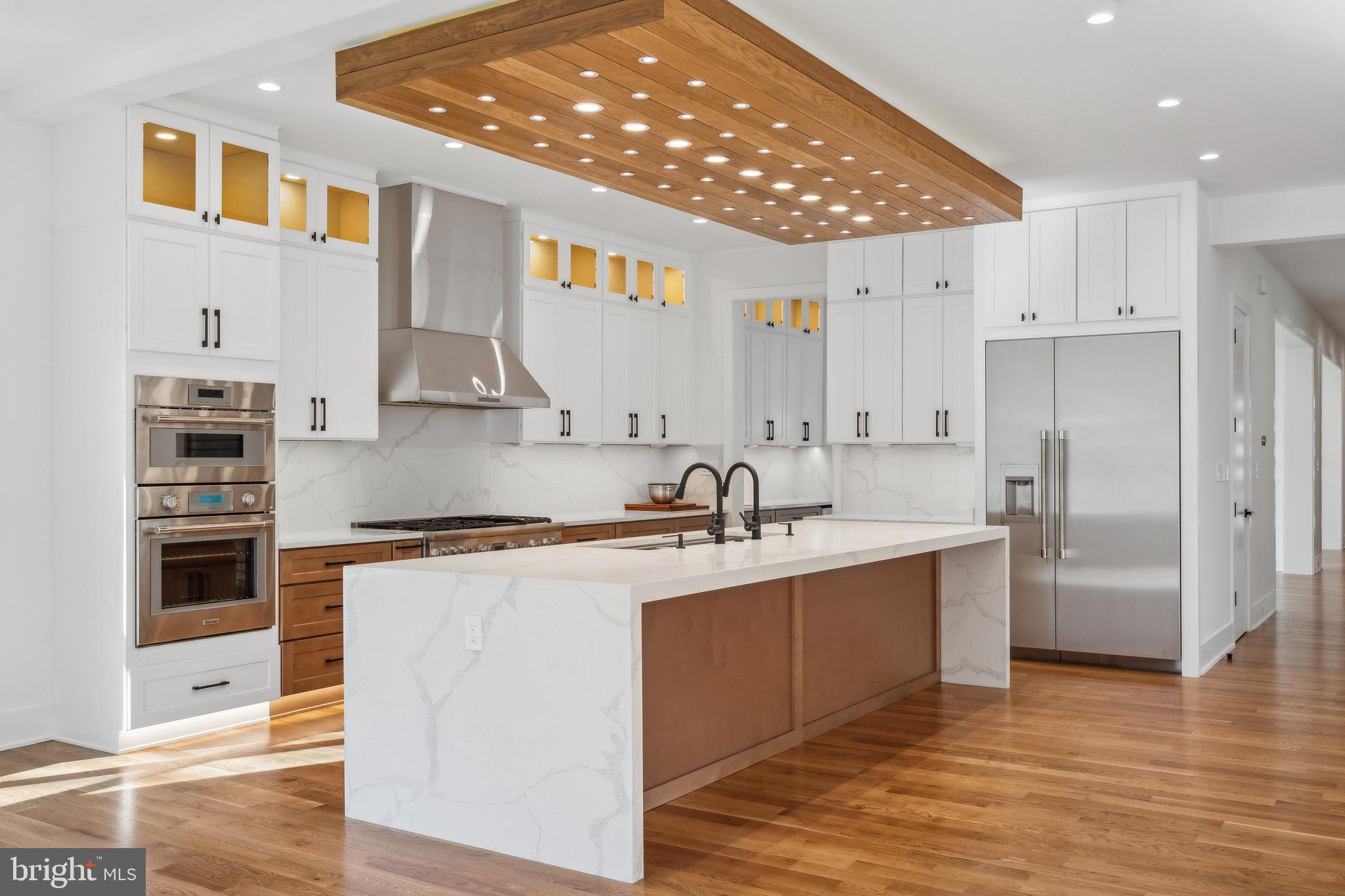 a kitchen with stainless steel appliances granite countertop a sink a stove and a refrigerator