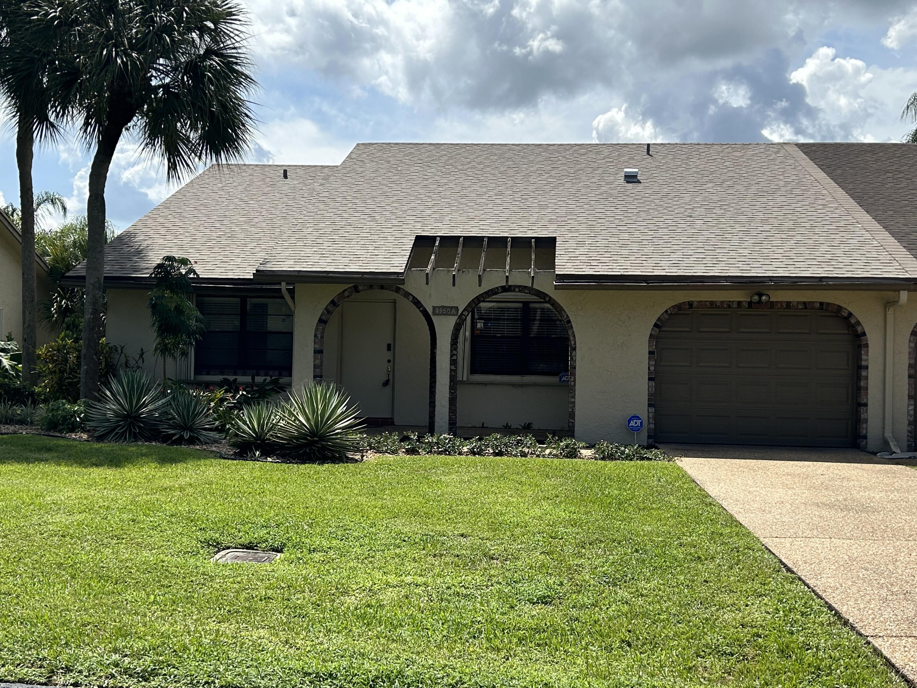 a front view of house with yard and garage