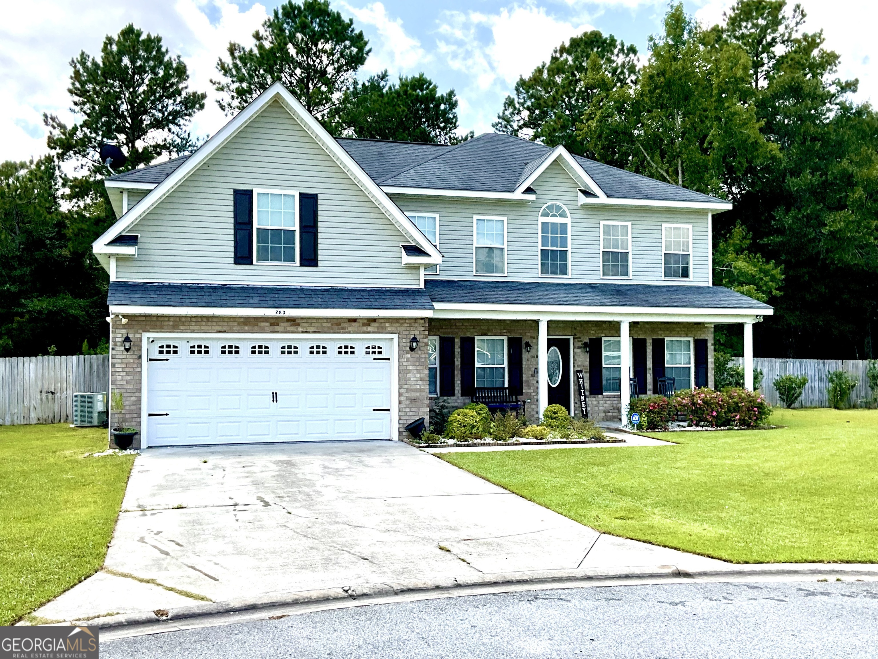 a front view of a house with a yard and trees