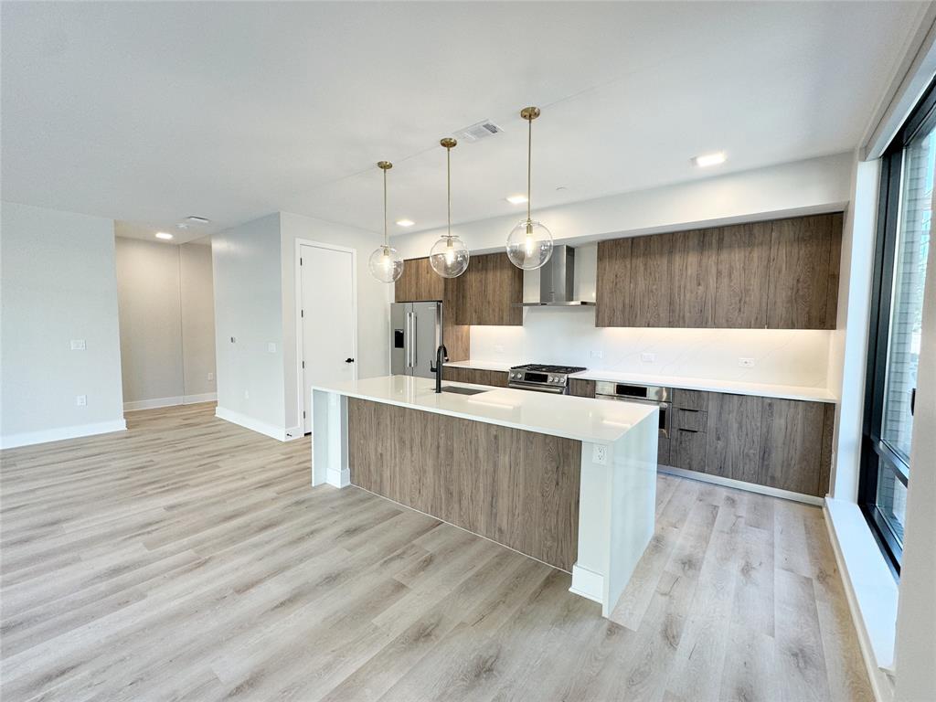 a large kitchen with a lot of counter space and wooden floor