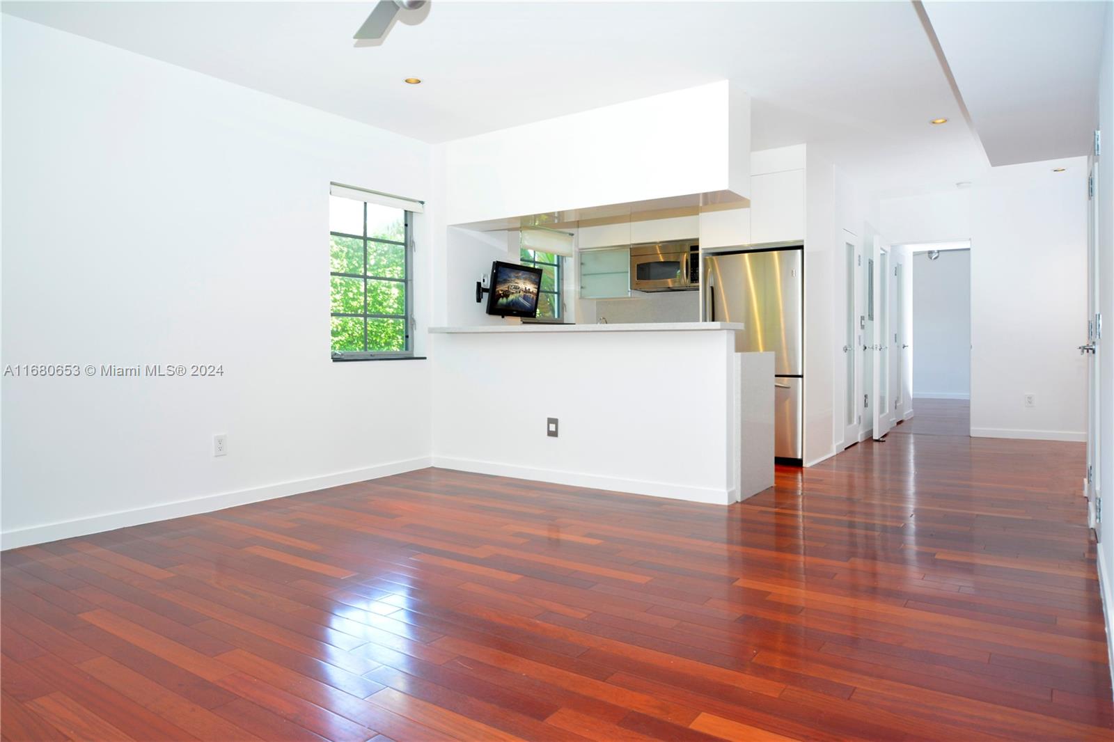 a view of a livingroom with wooden floor and a window