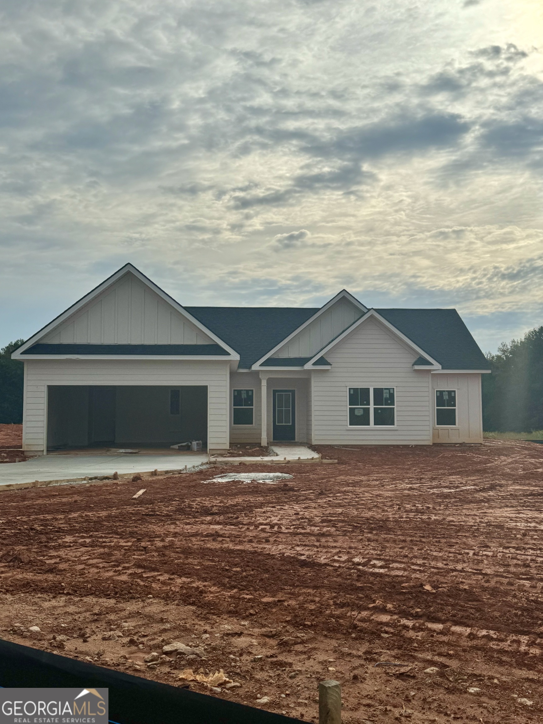 a front view of house with yard and trees in the background