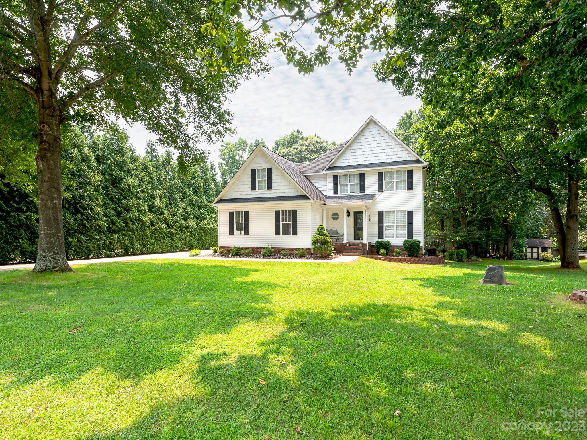 a front view of a house with a yard and trees