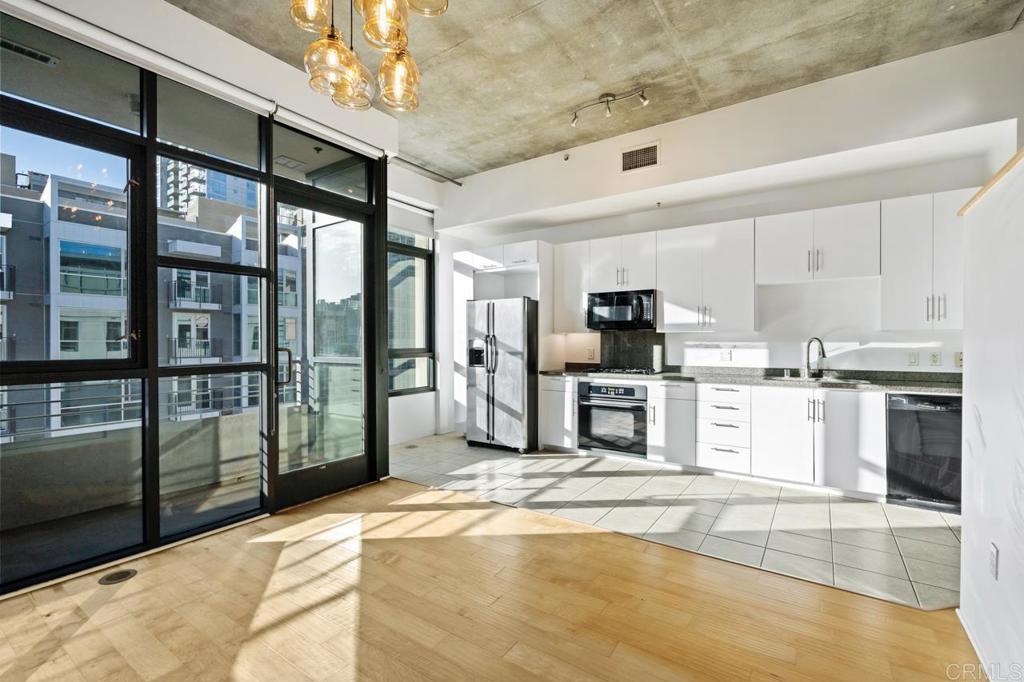 a kitchen with stainless steel appliances kitchen island granite countertop a refrigerator and cabinets