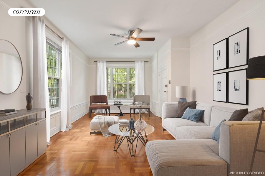 a living room with furniture a large window and a chandelier