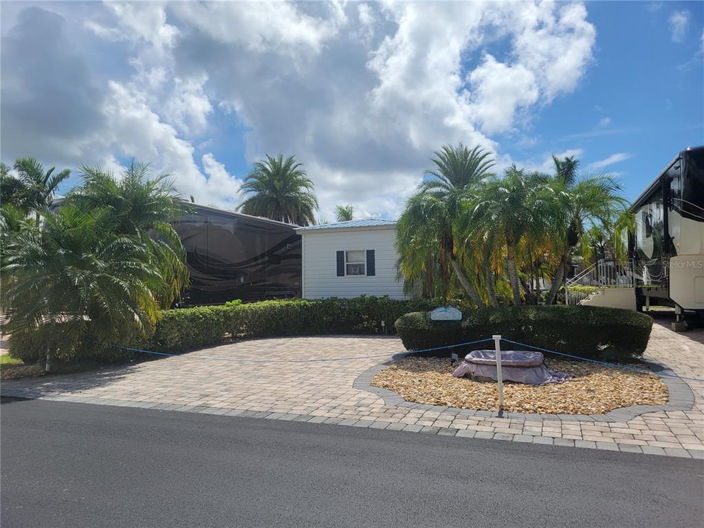 a view of a backyard with a fountain plants and palm trees