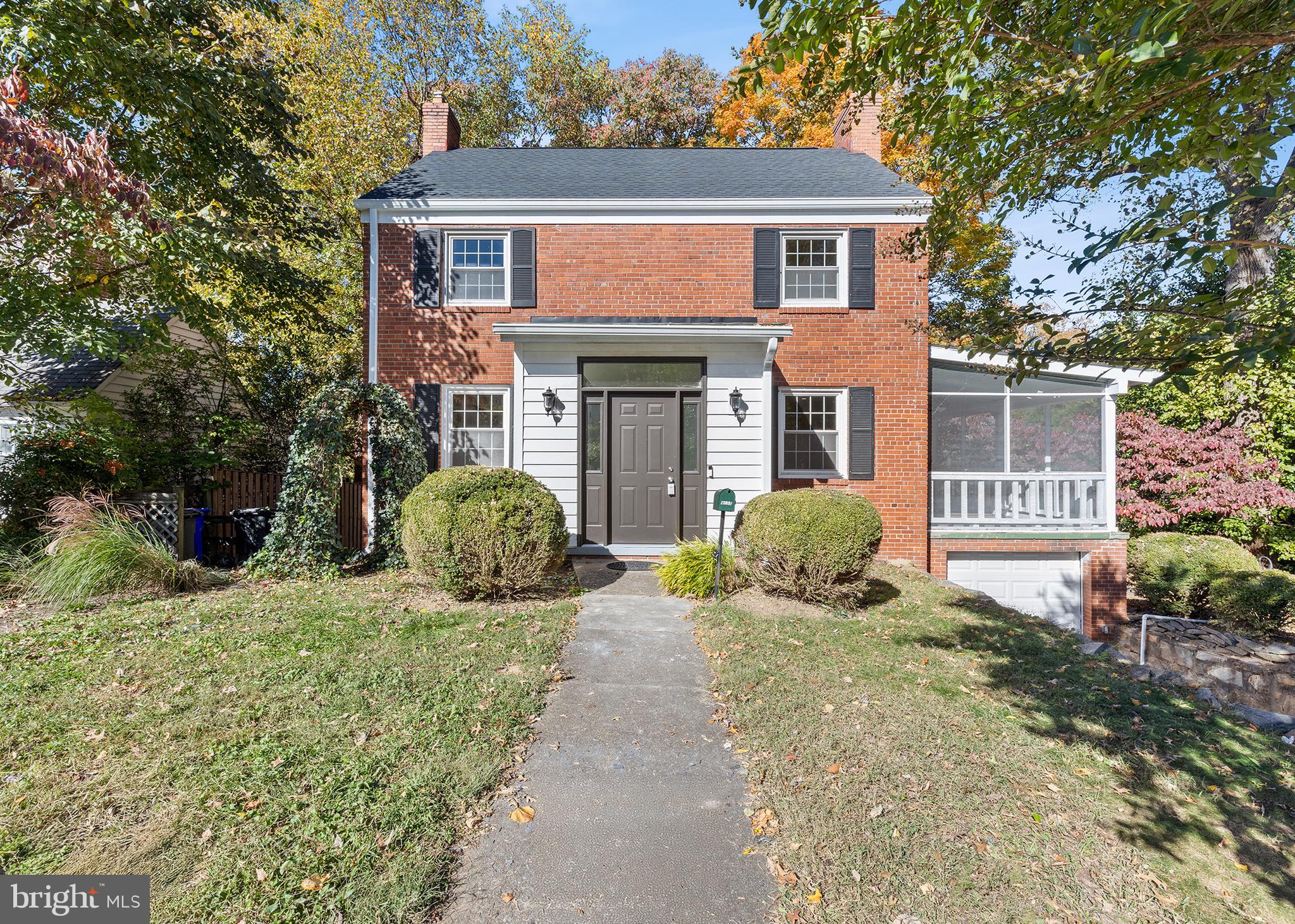 a front view of a house with yard and trees