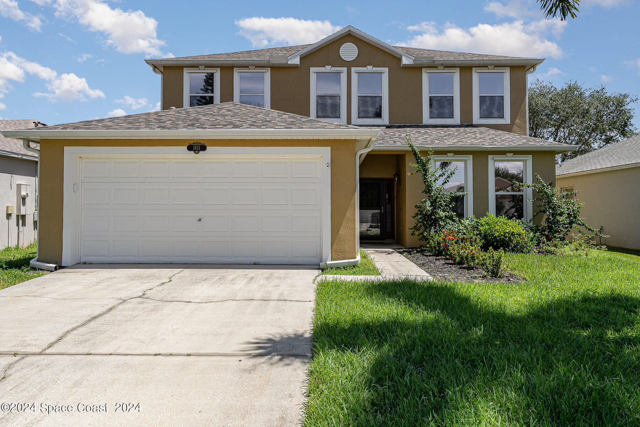 a front view of a house with a yard and garage