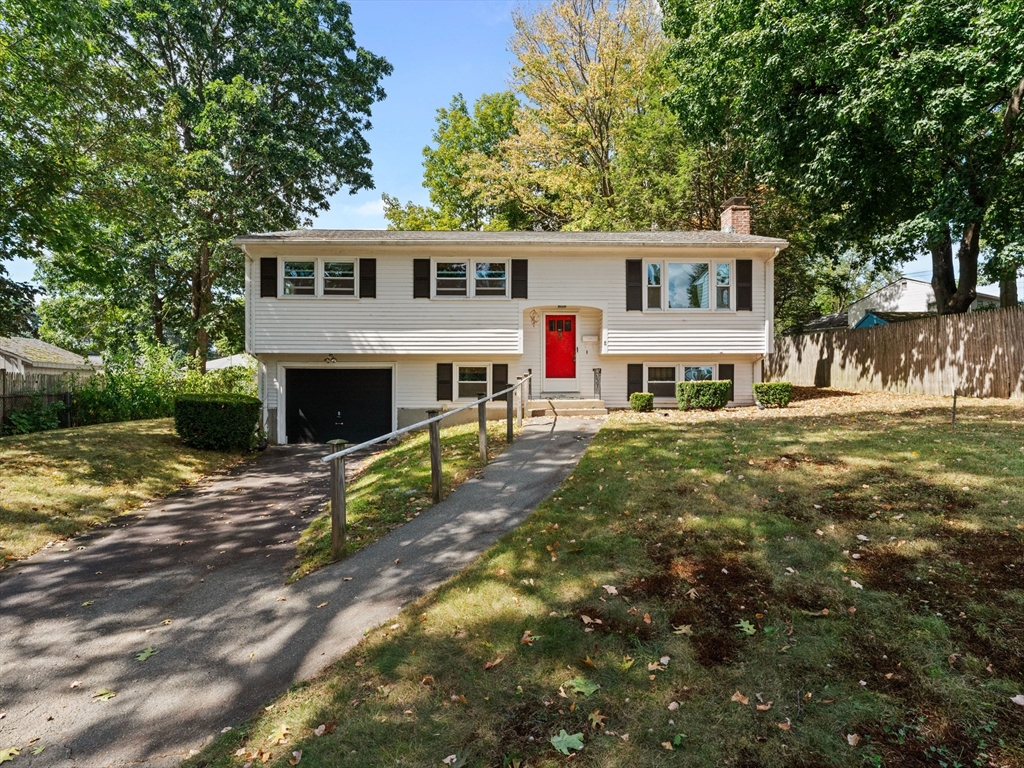 a view of house with outdoor space and trees in the background