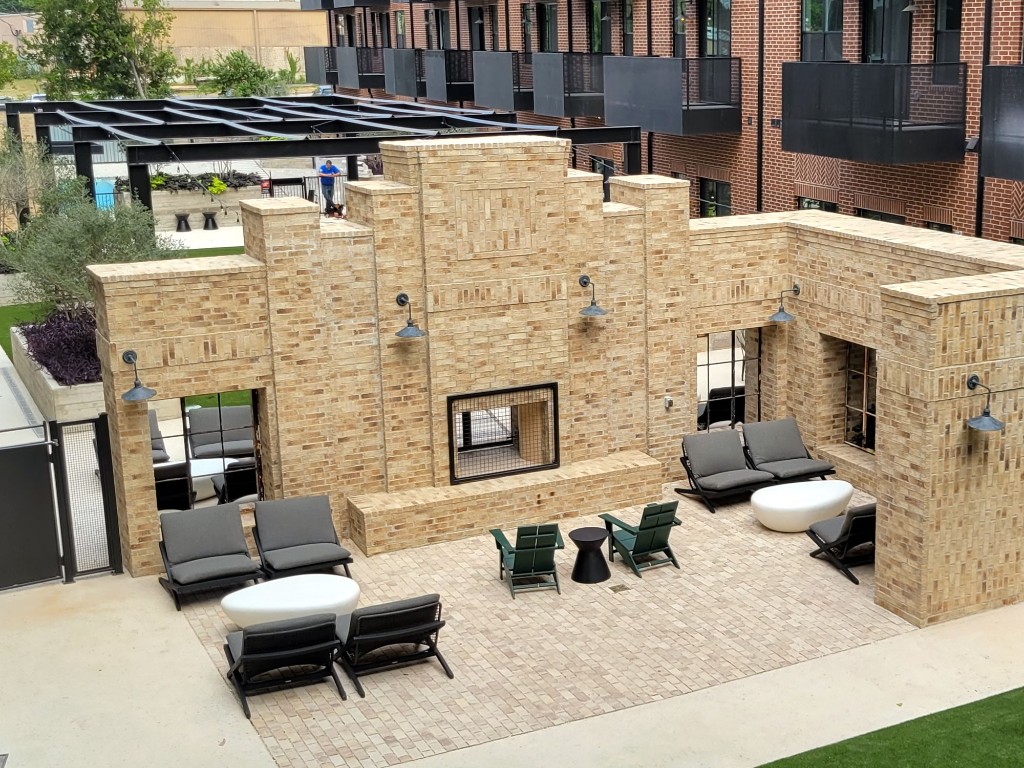 a view of a patio with couches chairs and a fireplace