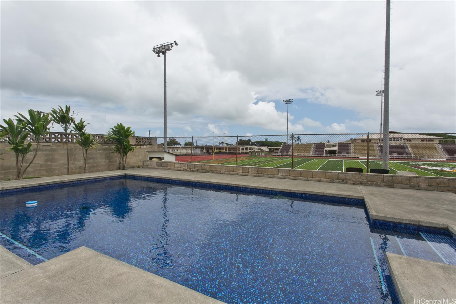 a view of a swimming pool with a yard and sitting space