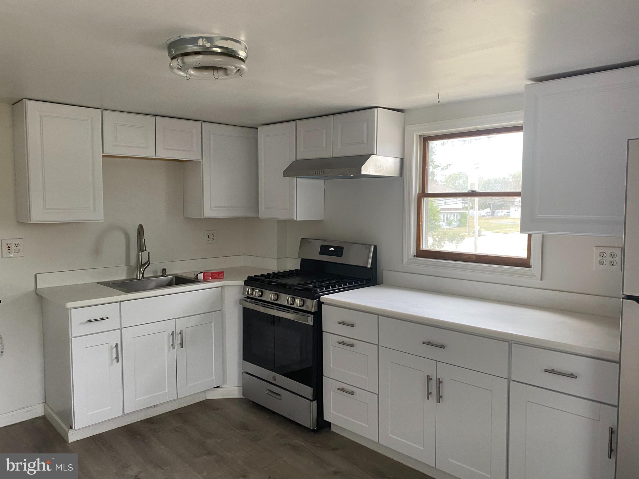 a kitchen with white cabinets and a stove top oven