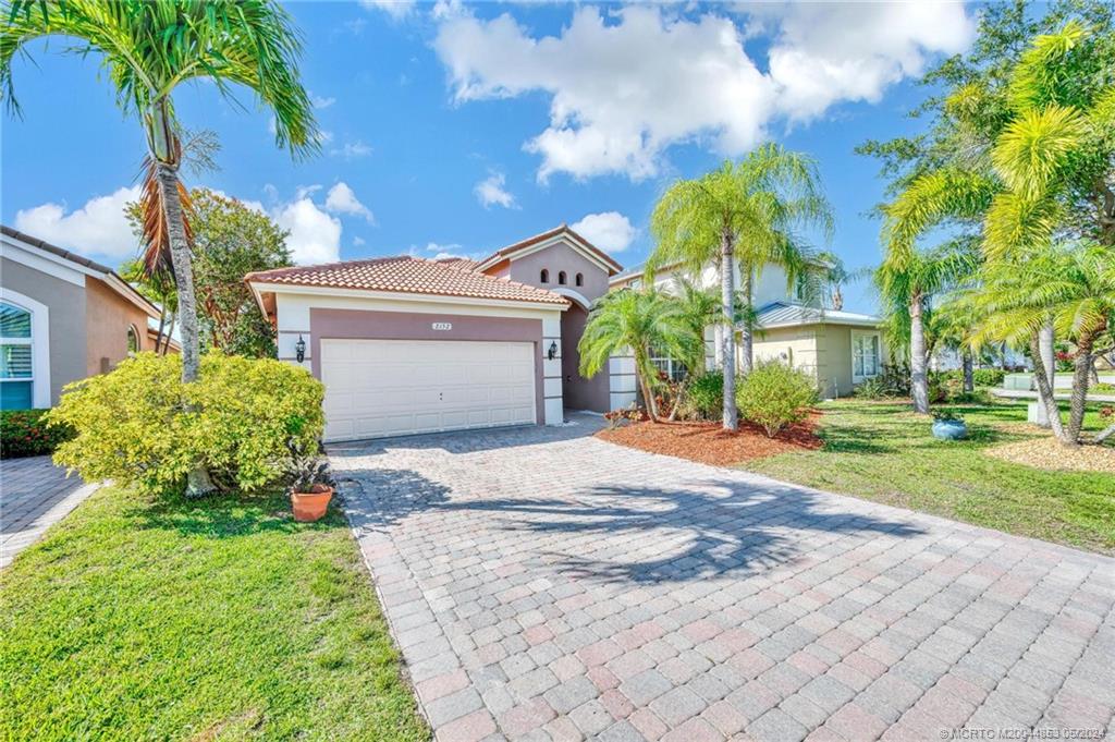 a front view of a house with a yard and a garage