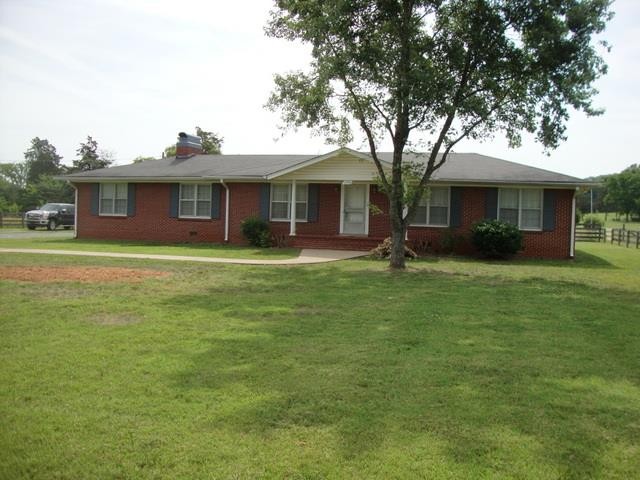 a front view of house with yard and trees