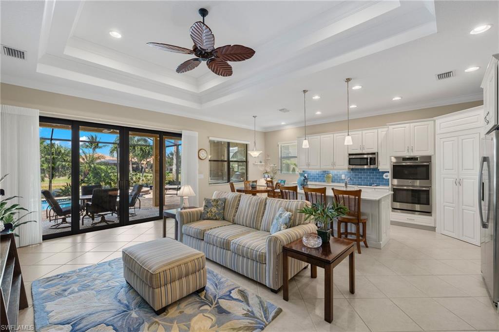 a living room with furniture kitchen area and a large window