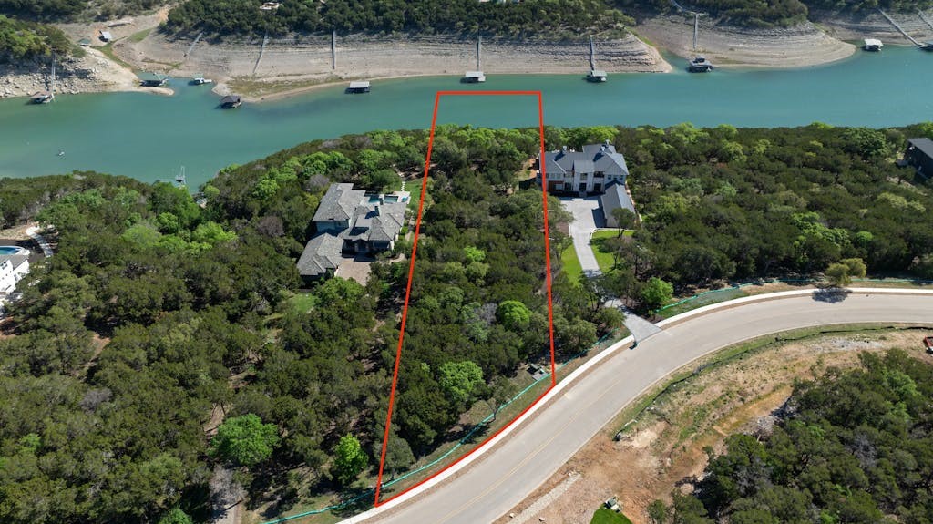 an aerial view of a house with a yard and lake view