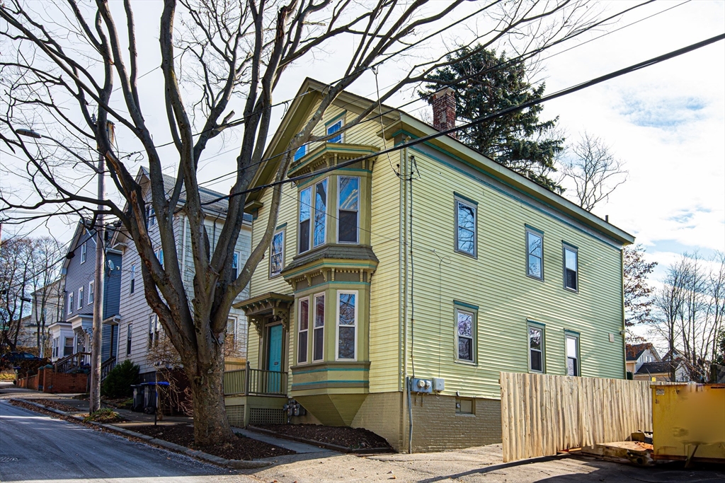 a front view of a house with a tree