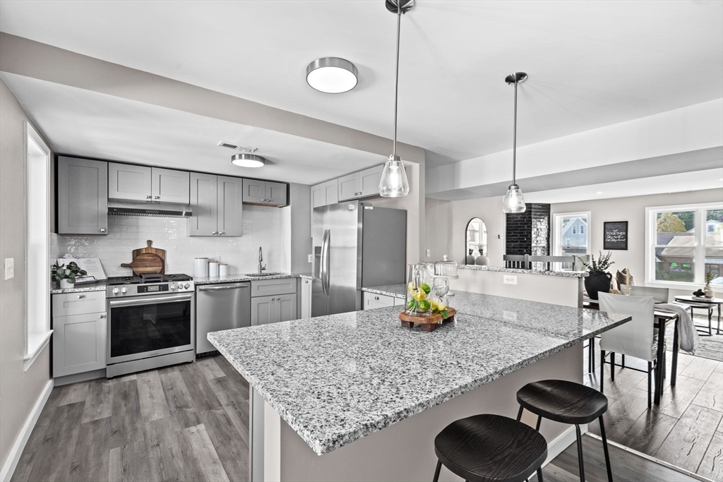 a kitchen with stainless steel appliances granite countertop a sink a stove and center island