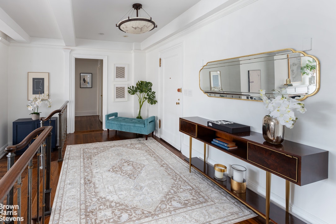 a living room with stainless steel appliances furniture a rug and a window