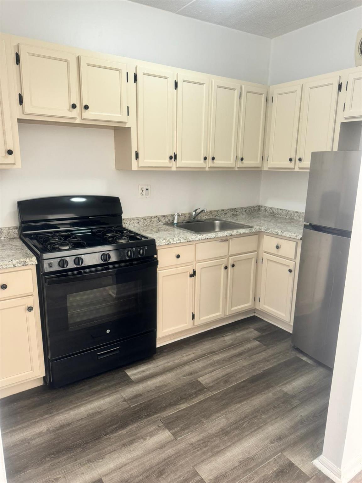 a kitchen with granite countertop white cabinets and white appliances