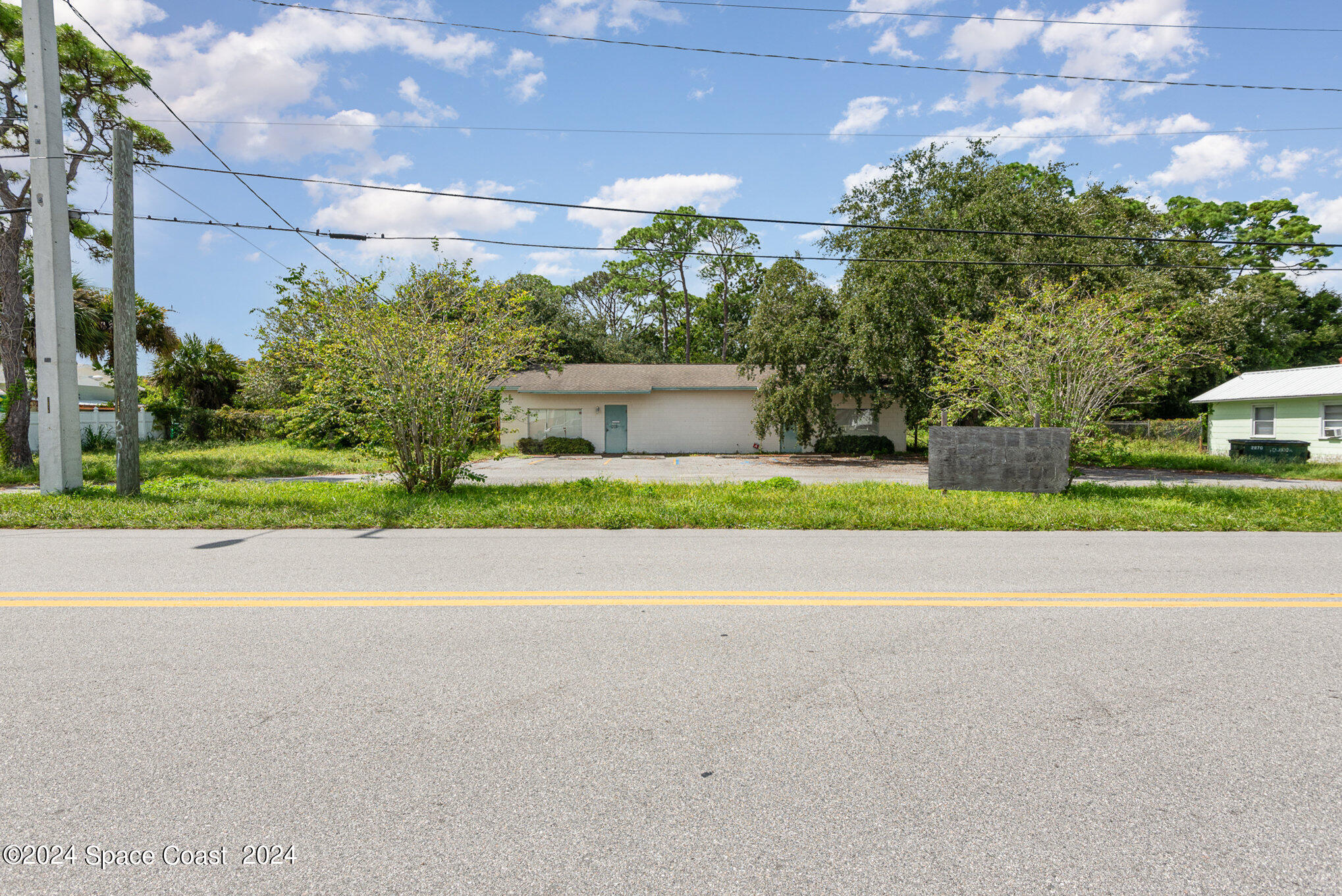 a house with a yard and a car park in front of it