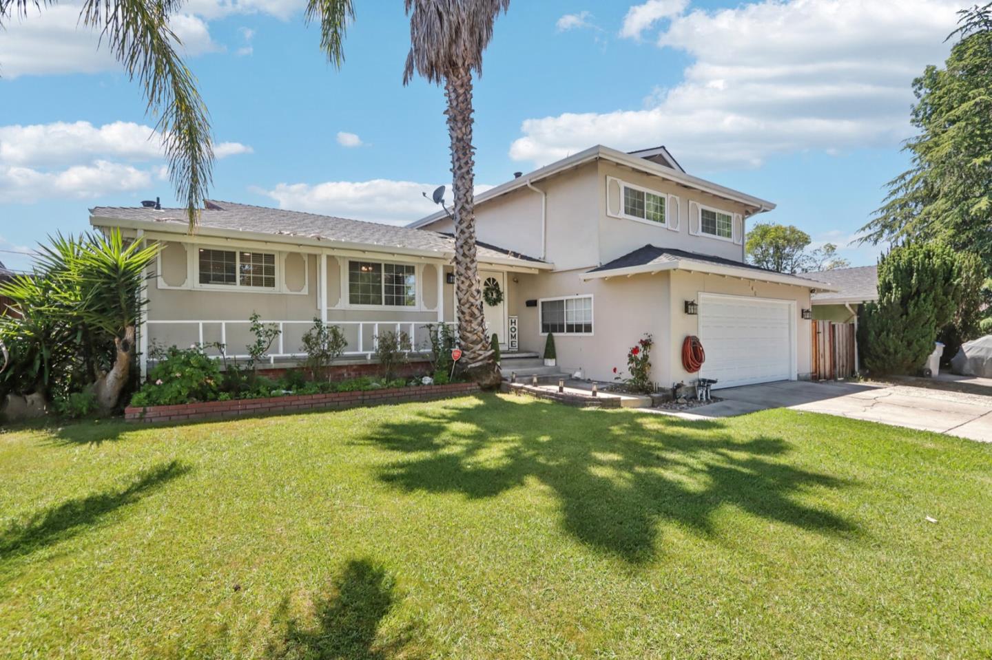 a view of a house with a big yard and a large tree