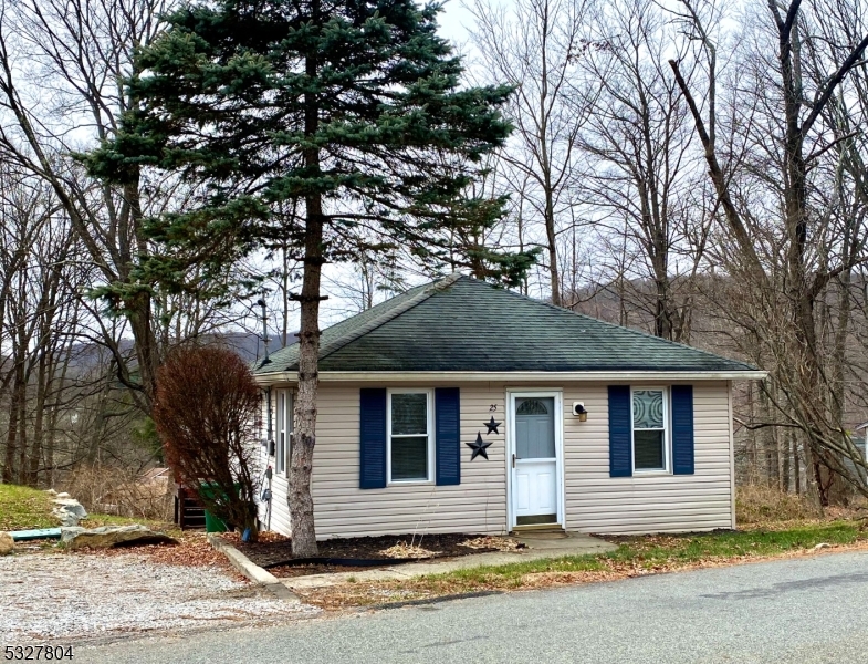 a front view of a house with a tree in front