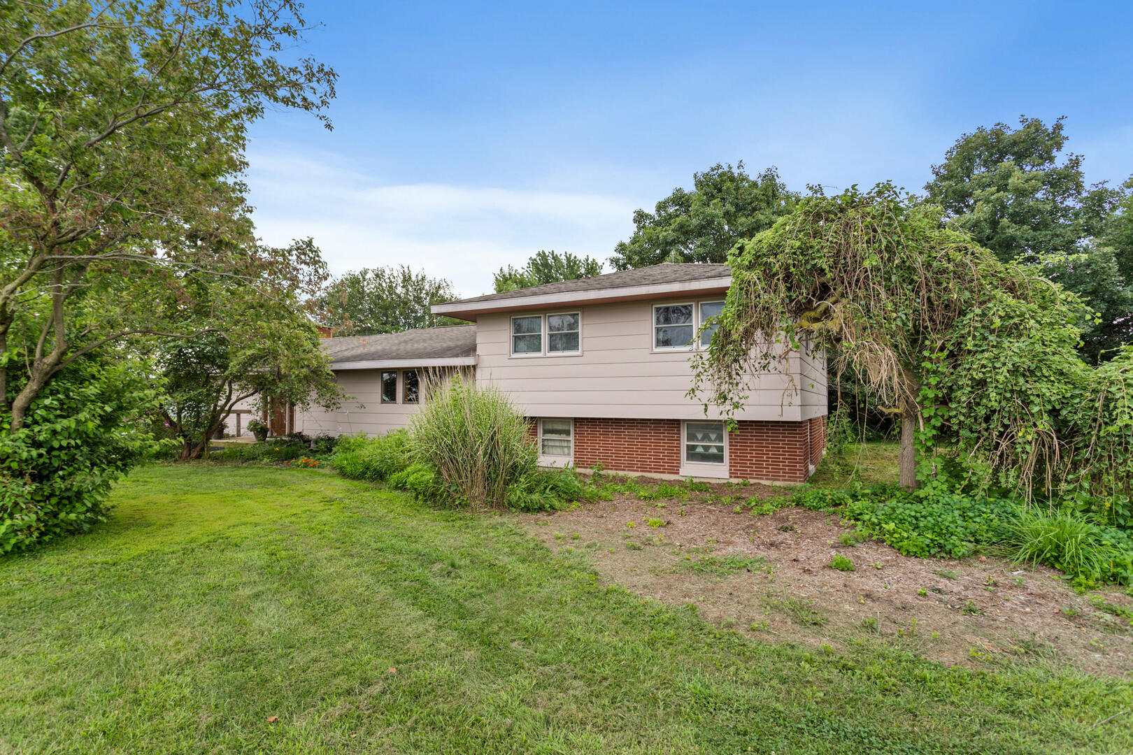 a front view of house with yard and trees