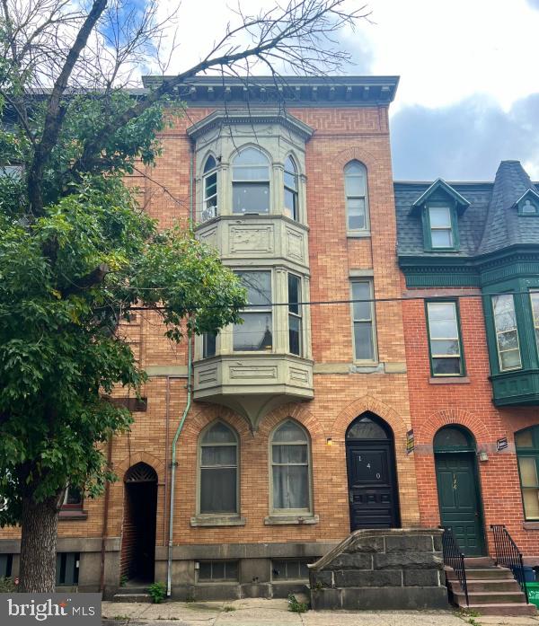 front view of a brick house with a yard