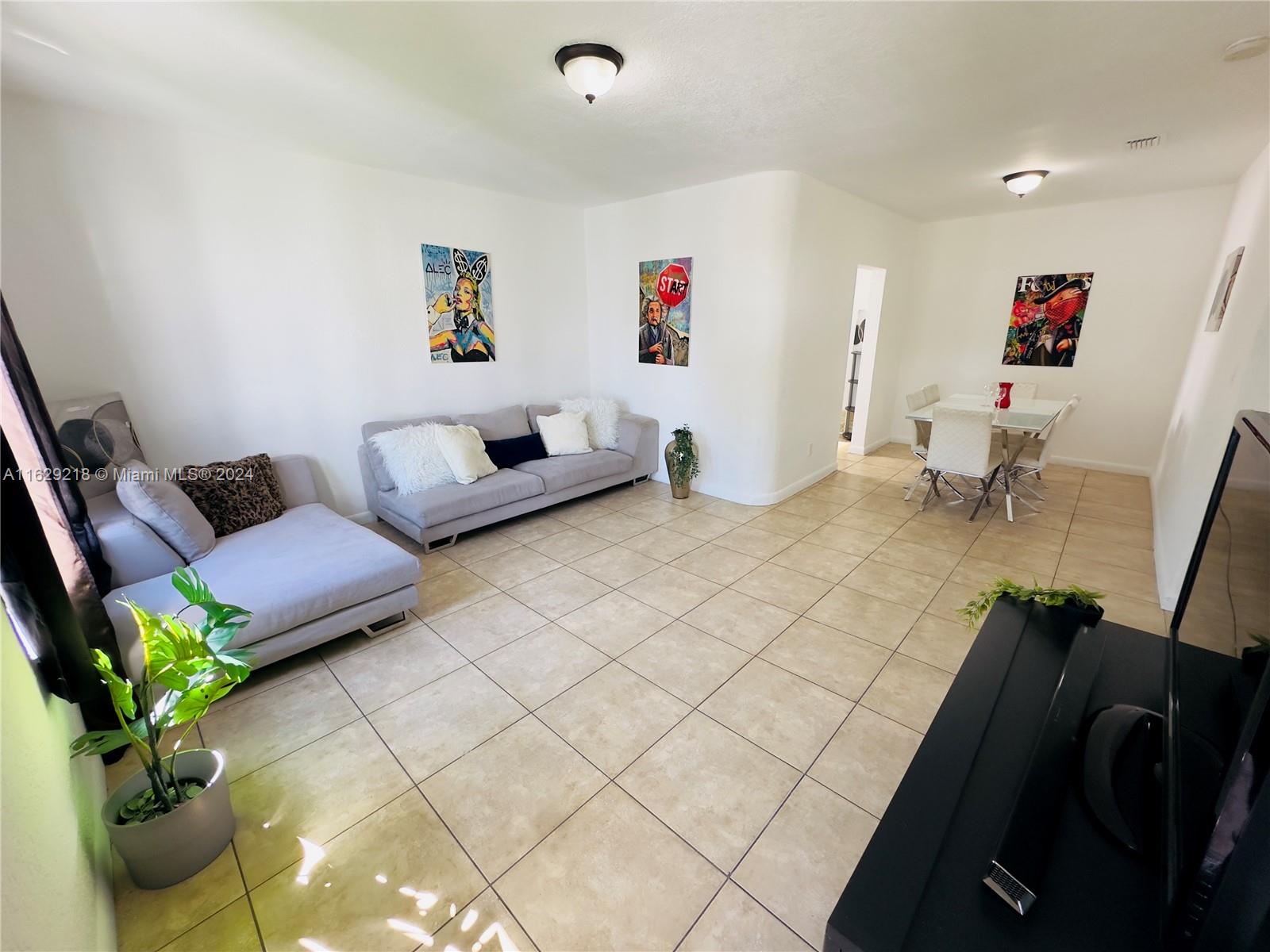 a living room with furniture and a potted plant