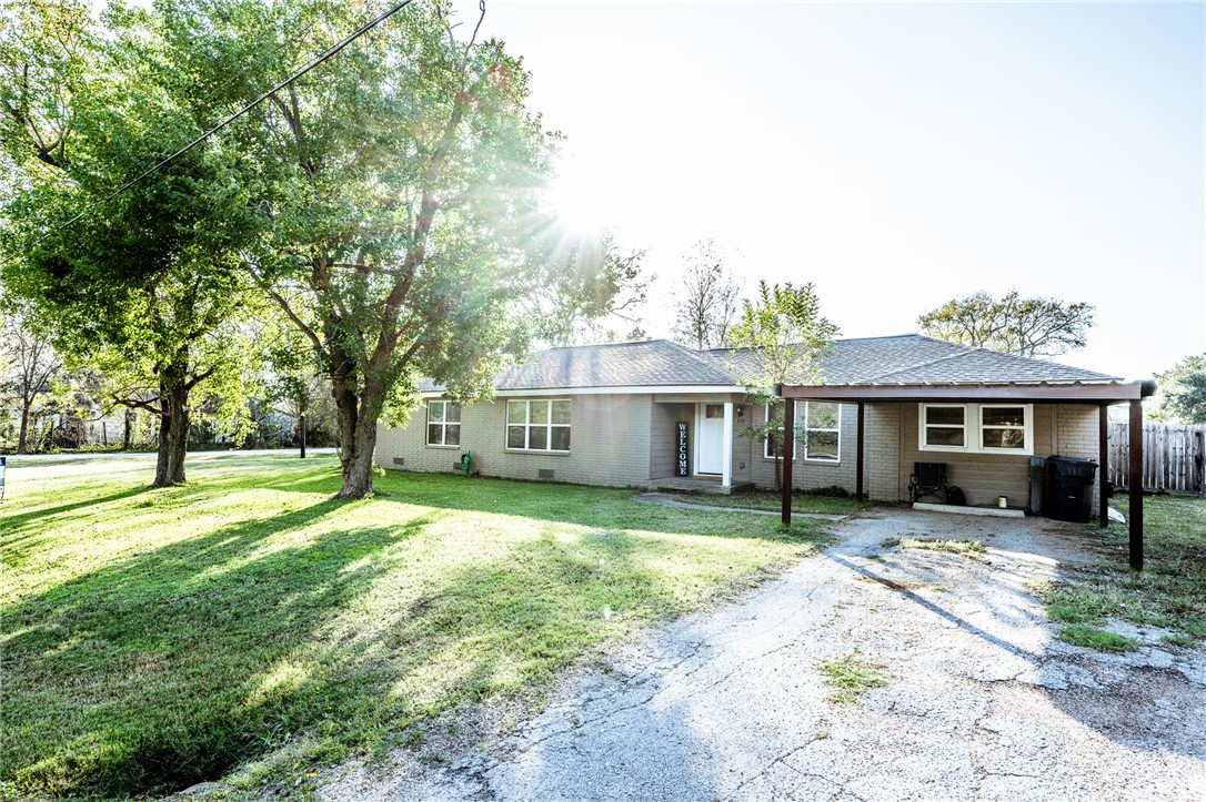 a front view of a house with a yard and trees