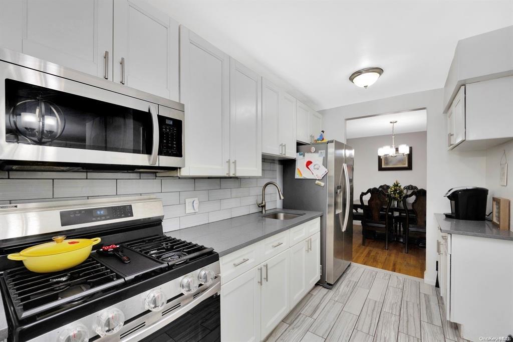 Kitchen featuring sink, white cabinets, and stainless steel appliances