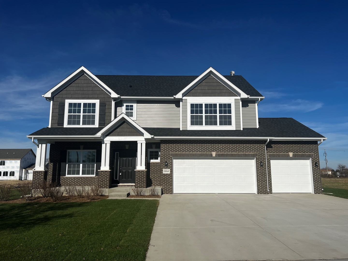 a front view of a house with a yard and trees