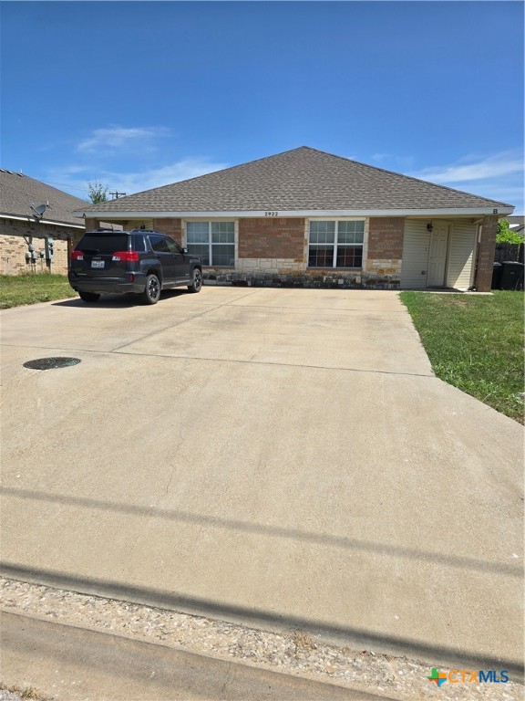 a view of house with yard and car parked