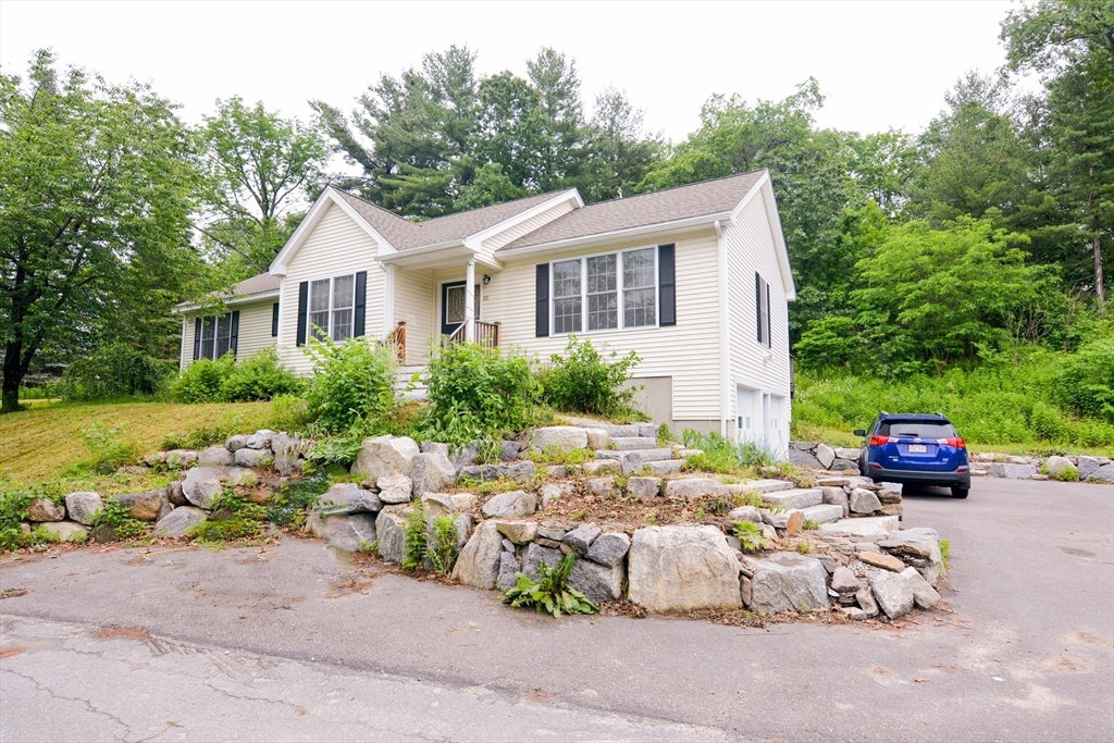 a view of a house with yard and a sitting area