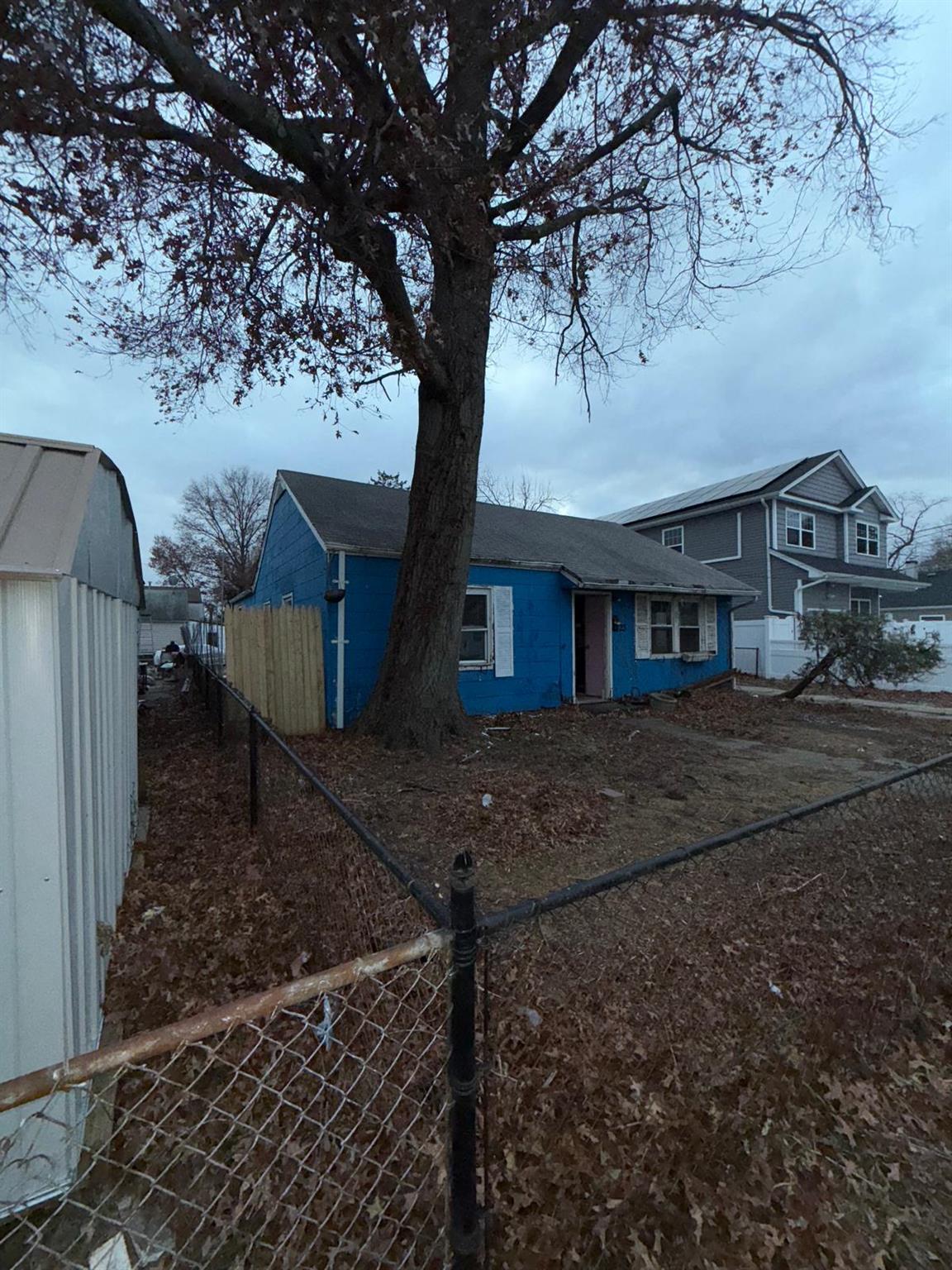 a view of a house with a yard and large tree