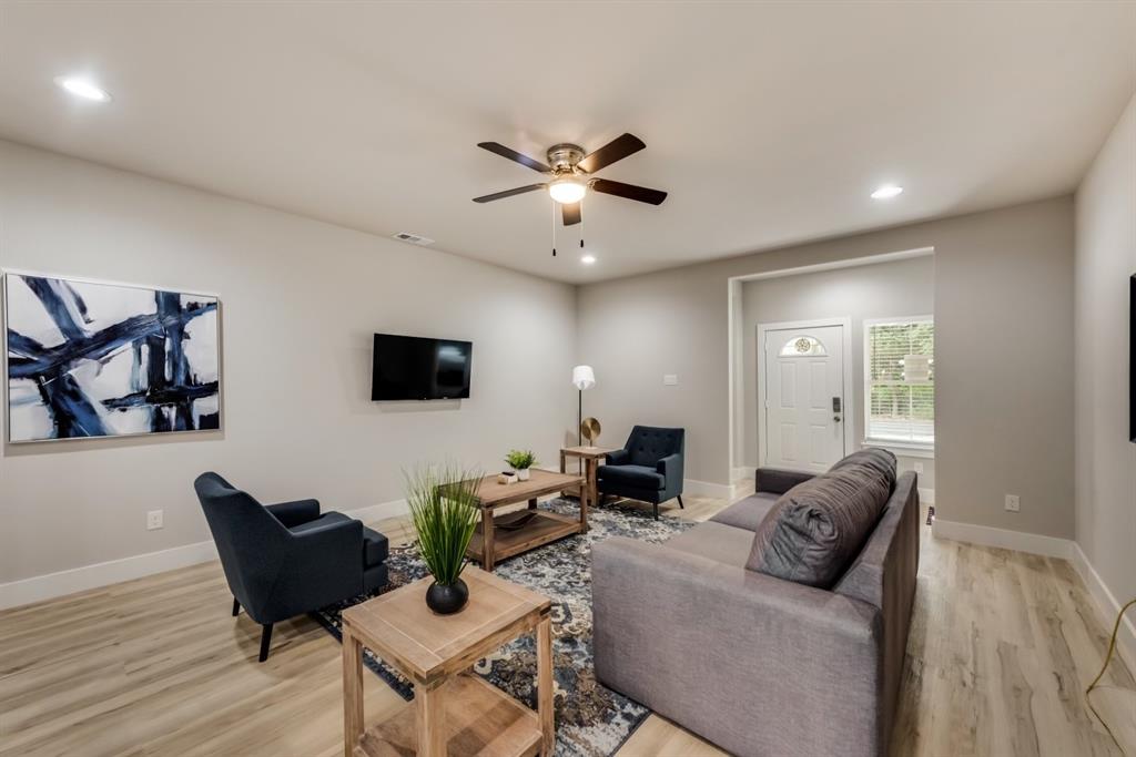 a living room with furniture and a wooden floor