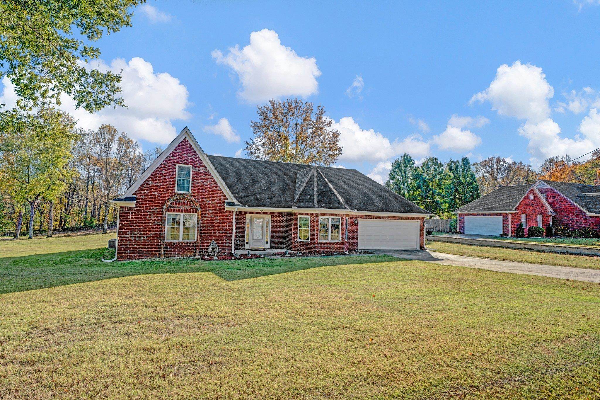 View of front of home with a front yard and a garage