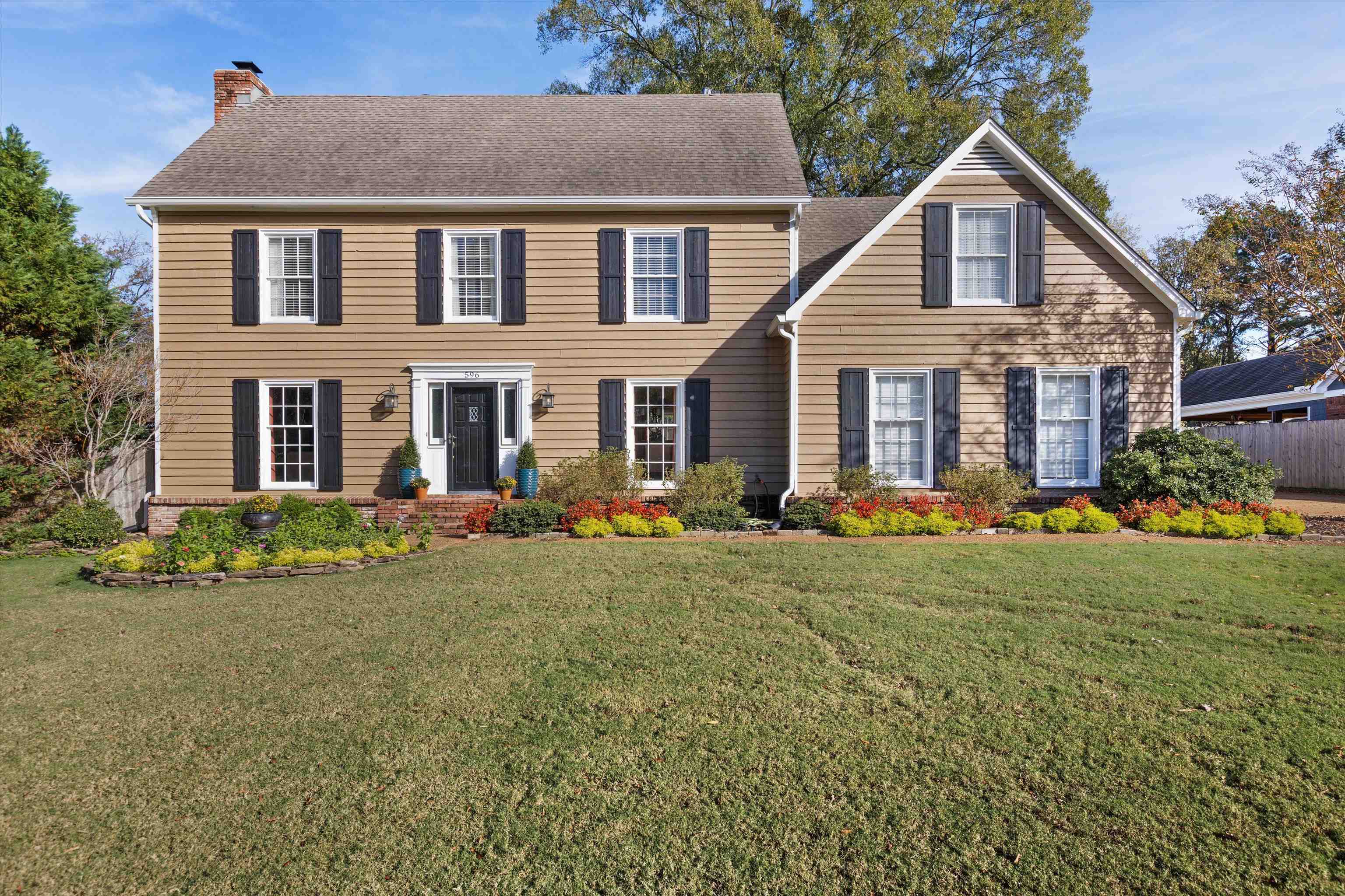 Colonial inspired home featuring a beautifully landscaped front yard