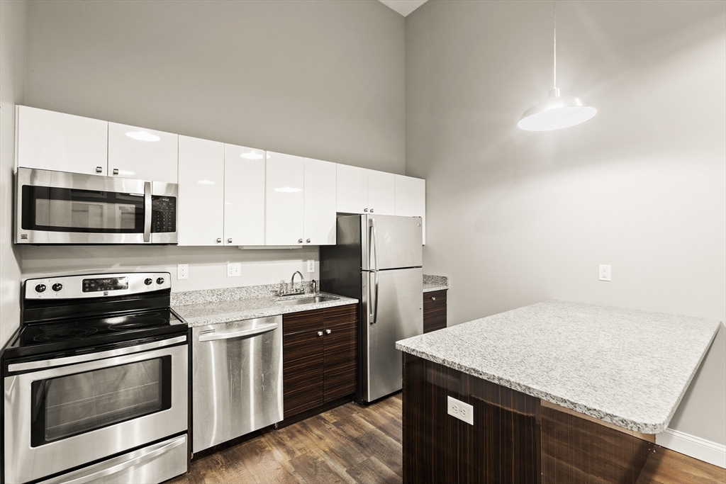 a kitchen with stainless steel appliances granite countertop a stove microwave and sink