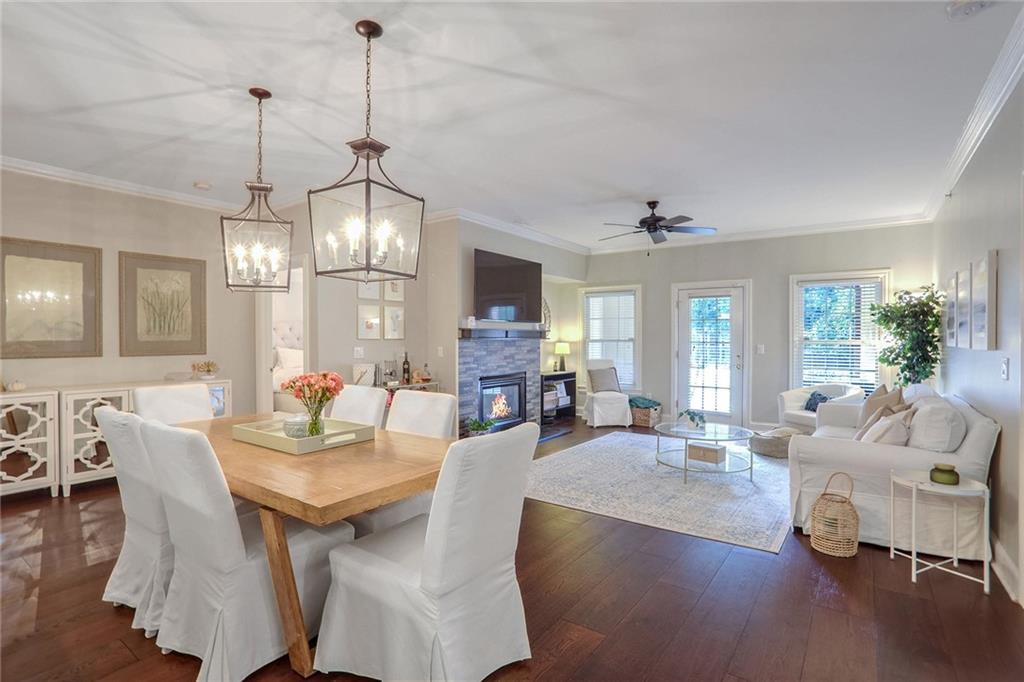 a view of a dining room and livingroom with furniture wooden floor a chandelier