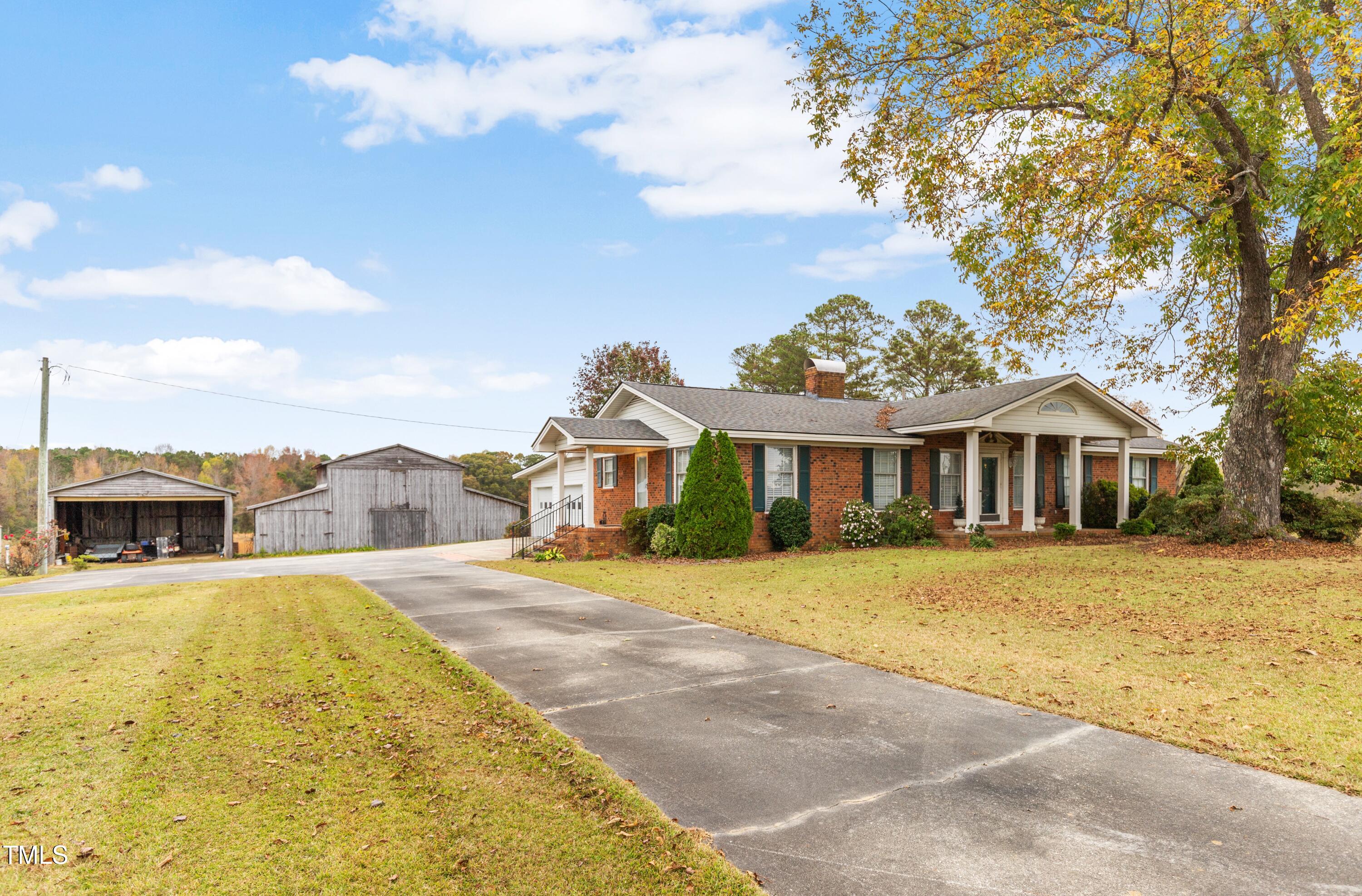 a view of a house with a big yard and large trees