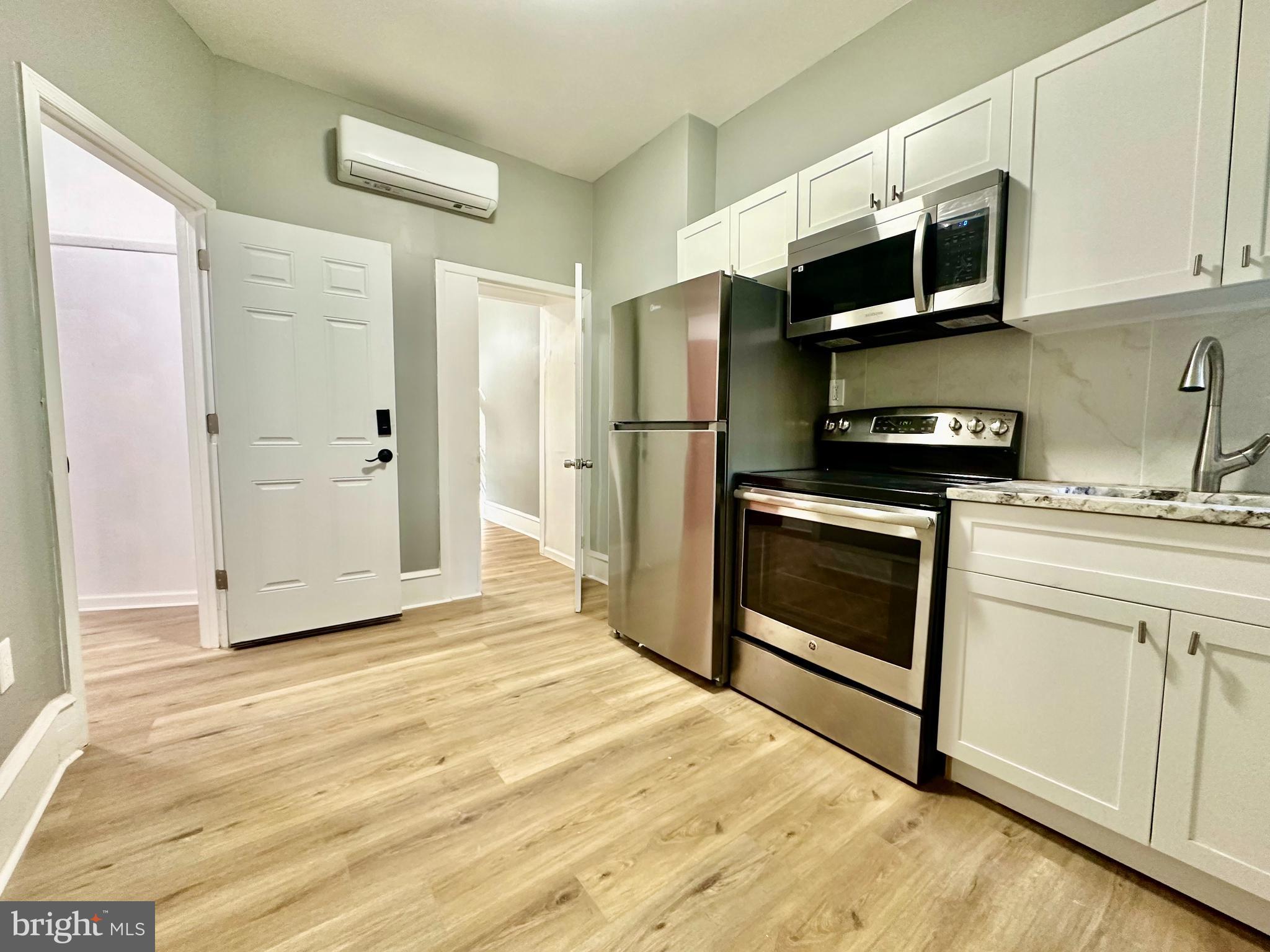 a kitchen with stainless steel appliances granite countertop a stove a microwave and a refrigerator