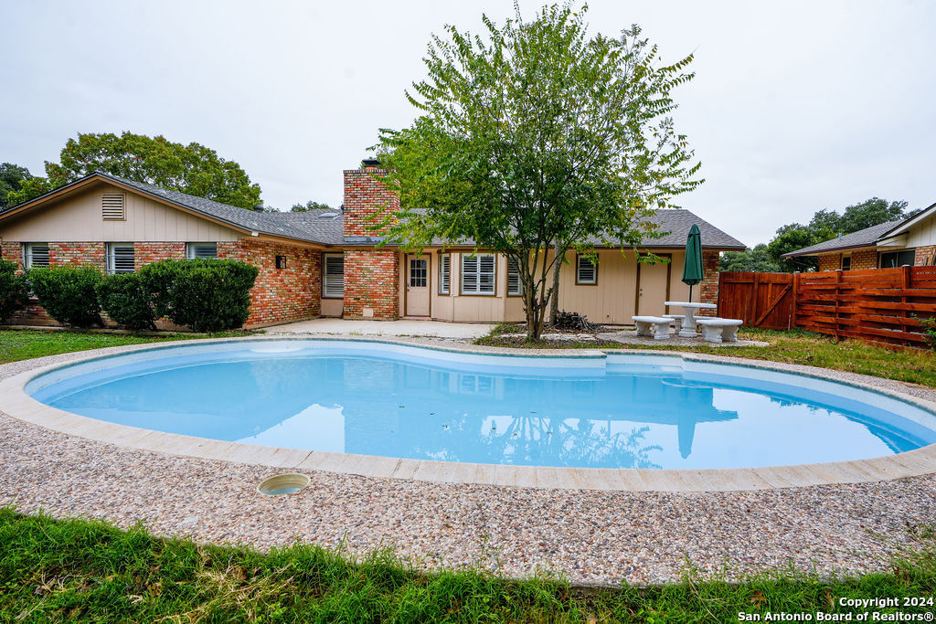 a view of a house with a swimming pool and a yard